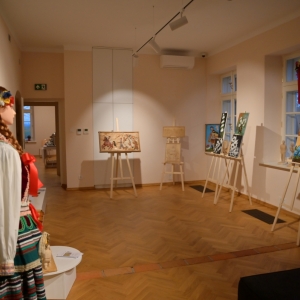 Sala wystawowa Centrum Pracy Twórczej w Ciechankach. Na sztalugach wyeksponowane obrazy kwiatów i płaskorzeźby.